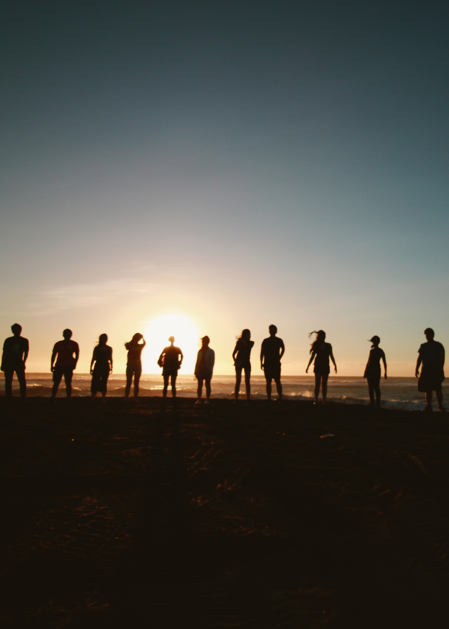 Group of people stood together at sunset